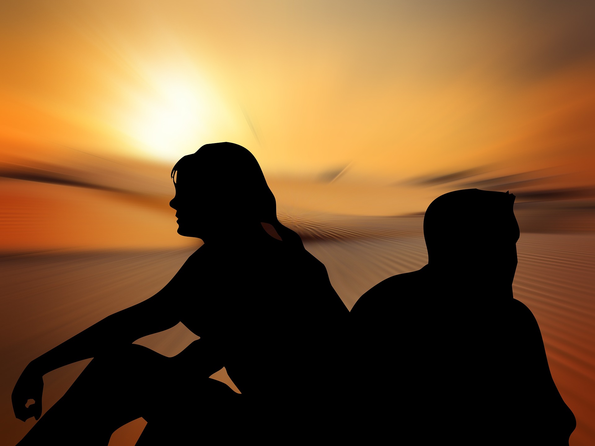 couple sitting back to back at beach