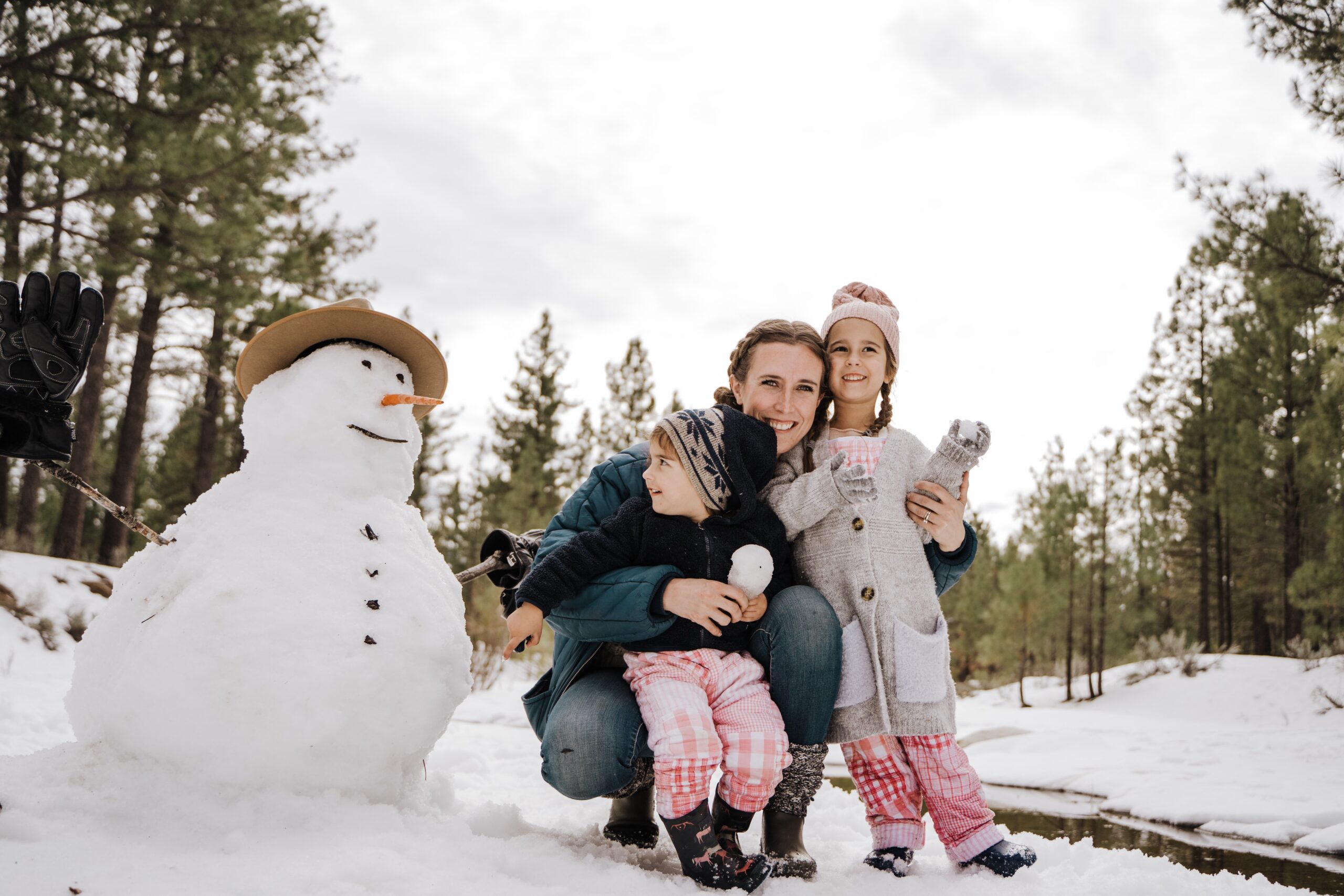 photo of mom and two kids with a snowman